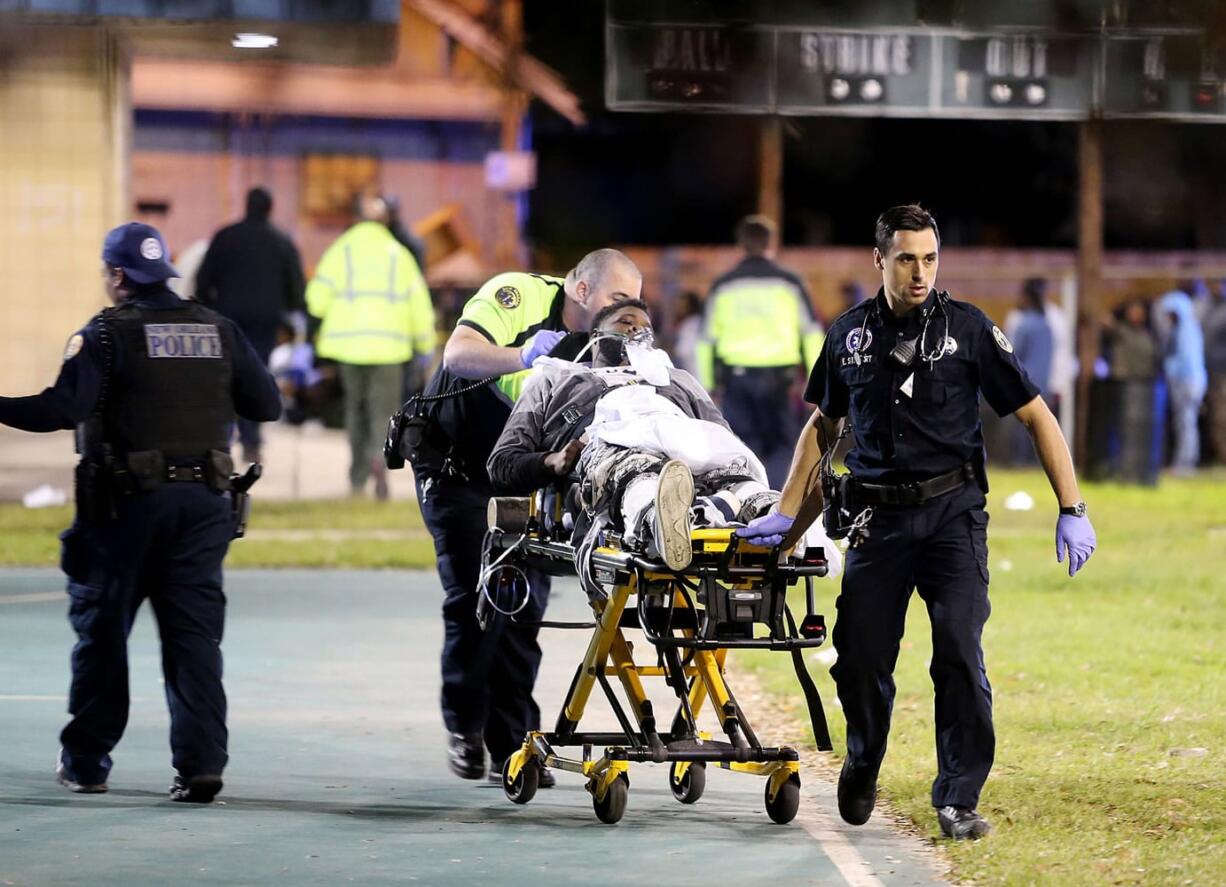 Paramedics with New Orleans EMS remove a man from the scene following a shooting in New Orleans on Sunday.