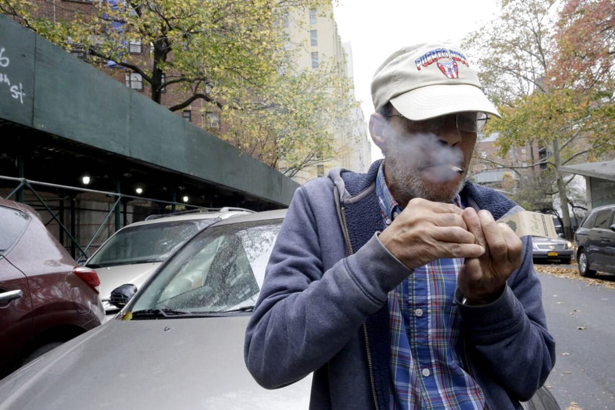 Luis Torres smokes a cigarette Thursday outside the New York City Housing Authority&#039;s Chelsea-Elliot Houses where he lives in New York.