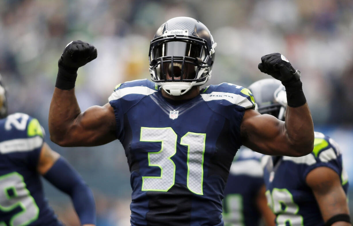 Seattle Seahawks strong safety Kam Chancellor (31) celebrates a hit on St. Louis Rams' Stedman Bailey in the first half Sunday.