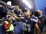 Seattle Seahawks' Golden Tate greets fans as he leaves the field after the team beat the St. Louis Rams in an NFL football game, Sunday, Dec. 29, 2013, in Seattle. The Seahawks won 27-9.