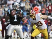 Carolina Panthers' Cam Newton (1) looks to pass as Washington Redskins' Trent Murphy (93) defends in the first half of an NFL football game in Charlotte, N.C., Sunday, Nov. 22, 2015.