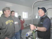 Mark Brown, right, a general manager for DeLaval Dairy Service, explains the automated systems to visitors at the Averill family dairy in Tillamook, Ore., Oct. 22, 2015. To many, this scenario represents the future of farming. As labor costs increase and the labor pool shrinks, farmers, such as the Averills, are turning to robotics and other technology to provide better care for their animals and increase efficiency.