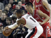 Houston Rockets guard Jeremy Lin, right, reaches in to knock the ball away from Portland Trail Blazers guard Damian Lillard during the first half on Nov.