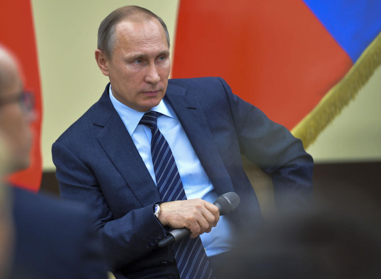 Russian President Vladimir Putin gestures while listens to a question during a meeting with representatives of "popular front" broad movement at the Novo-Ogaryovo residence outside Moscow, Russia, Friday, Nov. 27, 2015.