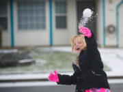 Hunter Schwabe, 6, of Battle Ground and first grader at Firm Foundation Christian School, throws a snowball at her dad, Ron Schwabe on Tuesday.