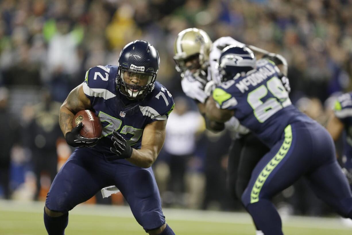 Seattle Seahawks' defensive end Michael Bennett returns a fumble for a touchdown against the New Orleans Saints in the first half of an NFL football game, Monday, Dec. 2, 2013, in Seattle.