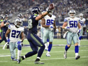 Seattle Seahawks' Jimmy Graham (88) celebrates after catching a long pass as Dallas Cowboys' J.J. Wilcox (27), David Irving (95) and Sean Lee (50) watch in the second half of an NFL football game Sunday, Nov. 1, 2015, in Arlington, Texas.