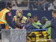 Seattle Seahawks' Ricardo Lockette holds up his hands as medical crew cart him off the field after suffering an unknown injury in the first half of an NFL football game against the Dallas Cowboys, Sunday, Nov. 1, 2015, in Arlington, Texas.