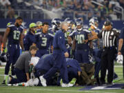 Seattle Seahawks head coach Pete Carroll and players huddle around as medical staff attend to wide receiver Ricardo Lockette (83) who suffered a neck injury against the Dallas Cowboys on Sunday, Nov. 1, 2015, in Arlington, Texas. Lockette has since returned to Seattle after having surgery.