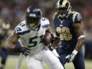 Seattle Seahawks outside linebacker Bruce Irvin (51) runs against St. Louis Rams tight end Jared Cook (89) after intercepting a pass during the first half on Monday, Oct. 28, 2013, in St. Louis.