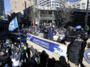 Seattle Seahawks quarterback Russell Wilson, center, waves to fans during the Super Bowl champions parade on Wednesday, Feb. 5, 2014, in Seattle. The Seahawks defeated the Denver Broncos 43-8 in NFL football's Super Bowl XLVIII on Sunday. (AP Photo/Ted S.