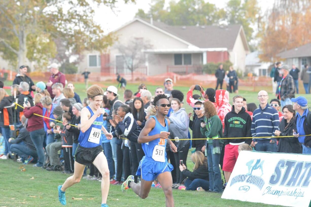 Silas Griffith of Ridgefield, right, sprints toward the finish en route to finishing fifth at the state cross country championships Saturday in Pasco.