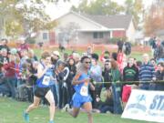 Silas Griffith of Ridgefield, right, sprints toward the finish en route to finishing fifth at the state cross country championships Saturday in Pasco.