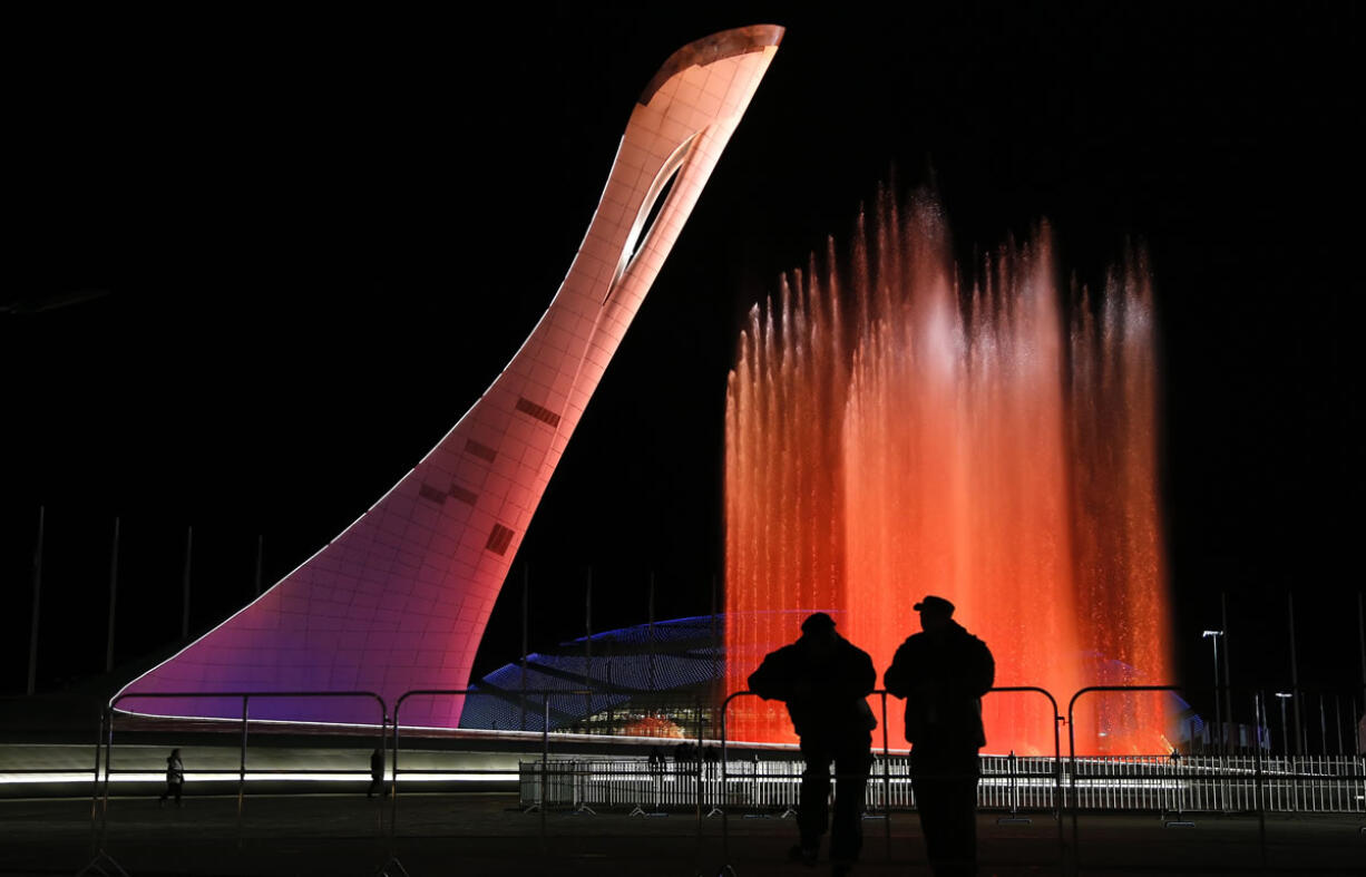 Security personnel watch a practice run of a fountain show to music from &quot;Swan Lake&quot; on the perimeter of the Olympic cauldron in preparation for the 2014 Winter Olympics on Thursday in Sochi, Russia. The cauldron will be lit with the Olympic torch during Friday's opening ceremonies.