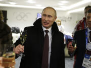 Russian President Vladimir Putin, center, toasts guests in the presidential lounge as Deputy Prime Minister Dmitry Kozak, right, looks on following the opening ceremony of the 2014 Winter Olympics, Friday, Feb. 7, 2014, in Sochi, Russia.