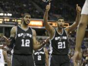 San Antonio Spurs' LaMarcus Aldridge, left, and Tim Duncan, question official Bennie Adams after he called Aldridge for a foul during the second half of an NBA basketball game against the Sacramento Kings in Sacramento, Calif., on Monday.