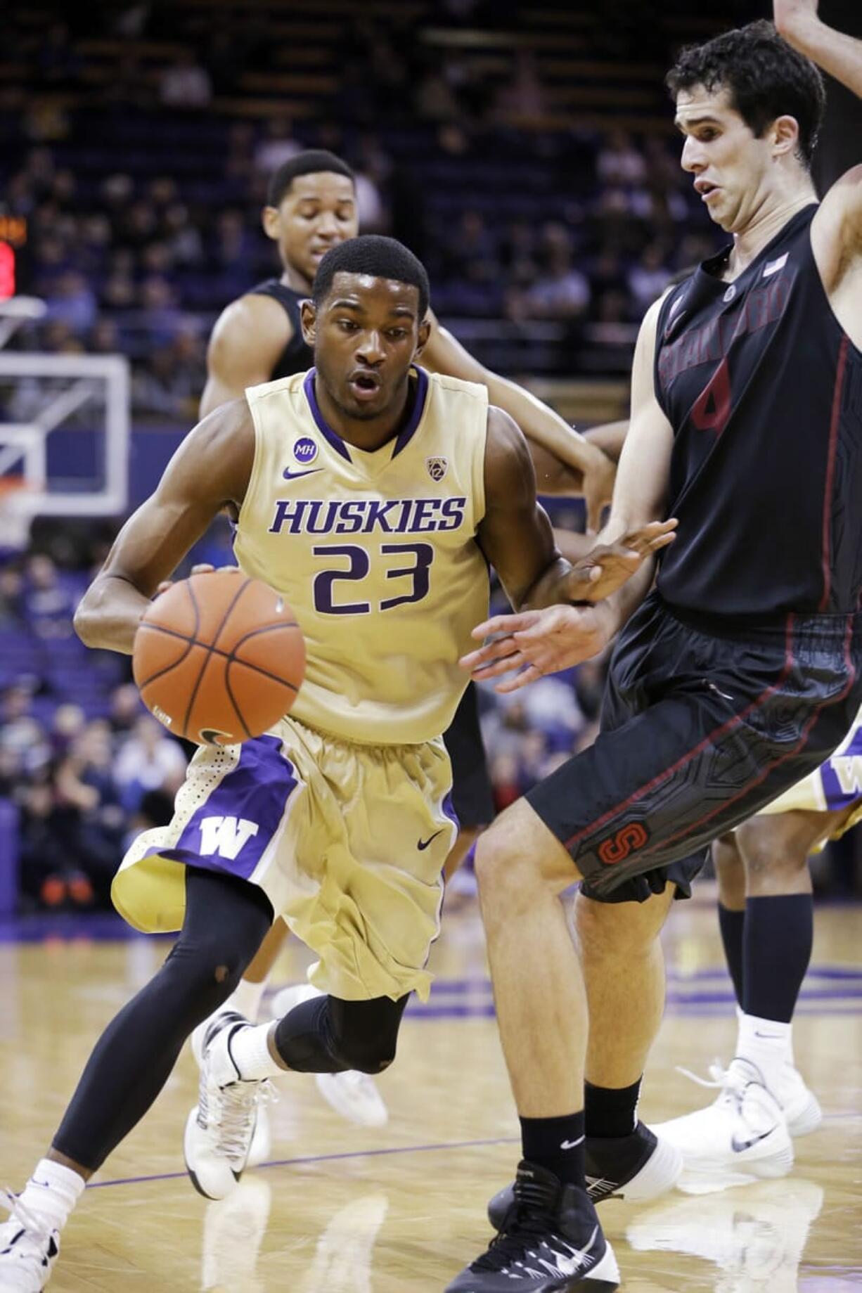 Washington's C.J. Wilcox (23) tries to drive past Stanford's Stefan Nastic in the first half of an NCAA college basketball game Wednesday, Feb. 12, 2014, in Seattle.