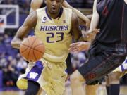 Washington's C.J. Wilcox (23) tries to drive past Stanford's Stefan Nastic in the first half of an NCAA college basketball game Wednesday, Feb. 12, 2014, in Seattle.