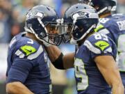 Seattle Seahawks quarterback Russell Wilson, left, celebrates with wide receiver Doug Baldwin, right, after Wilson passed to Baldwin for a touchdown against the Pittsburgh Steelers in the first half of an NFL football game, Sunday, Nov. 29, 2015, in Seattle. (AP Photo/Ted S.