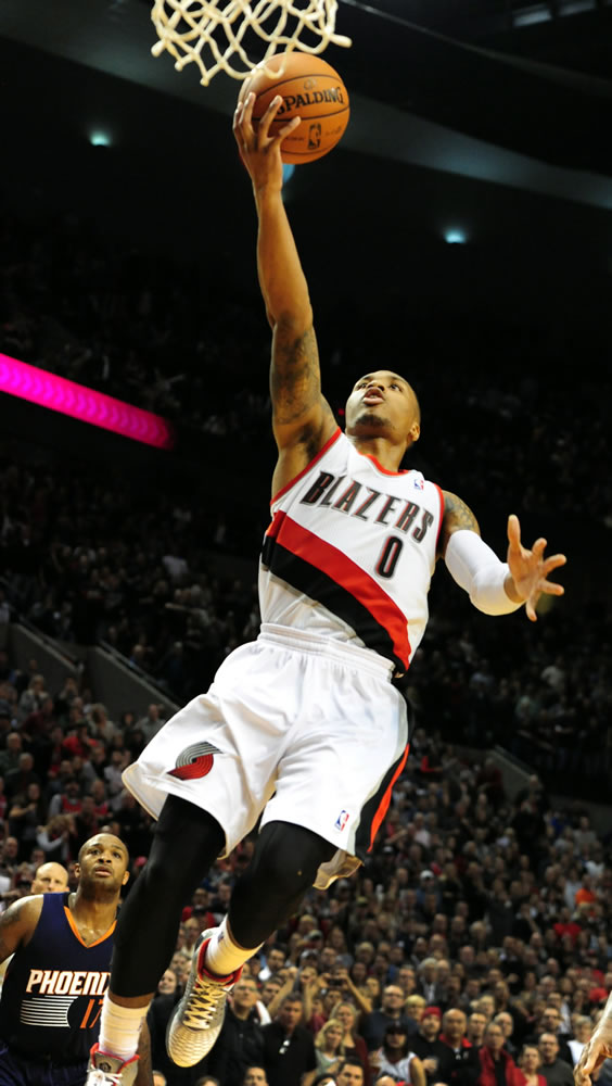 Portland Trail Blazers point guard Damian Lillard (0) drives to the basket past Phoenix Suns small forward P.J. Tucker (17) to score the winning basket late in the fourth quarter of an NBA basketball game on Wednesday, Nov. 13, 2013, in Portland, Ore. The Blazers won the game 90-89.