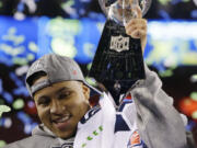 Seattle Seahawks' Malcolm Smith celebrates with the Vince Lombardi Trophy after the NFL Super Bowl XLVIII football game against the Denver Broncos Sunday, Feb. 2, 2014, in East Rutherford, N.J. The Seahawks won 43-8.