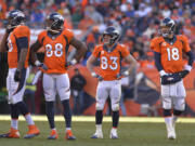 ADVANCE FOR WEEKEND EDITIONS, JAN. 25-26 - In this Jan. 12, 2014, file photo, Denver Broncos tight end Julius Thomas (80), wide receiver Demaryius Thomas (88), wide receiver Wes Welker (83) and quarterback Peyton Manning (18) wait as officials review a fumbled pass by Thomas during the second quarter against the San Diego Chargers in an AFC divisional NFL playoff football game in Denver.  No team in the 93-year history of the NFL ever had that many players catch at least 60 passes or reach the end zone 10 or more times until the Broncos put up a record 606 points.