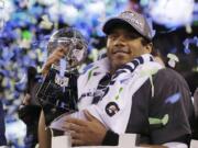 Seattle Seahawks' quarterback Russell Wilson holds the Lombardi Trophy after the NFL Super Bowl XLVIII football game Sunday, Feb. 2, 2014, in East Rutherford, N.J. The Seahawks won 43-8.