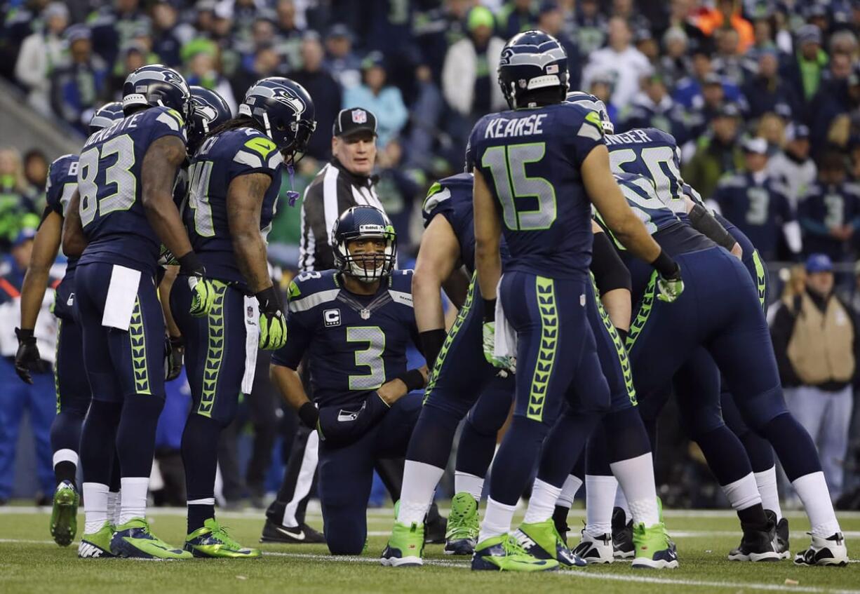 Seattle Seahawks' Russell Wilson (3) speaks to his teammates, including receivers Ricardo Lockette (83) and Jermaine Kearse (15), during huddle in the first half of the NFC championship against the San Francisco 49ers in Seattle. It's an unheralded group that have been catching passes from Wilson all season.