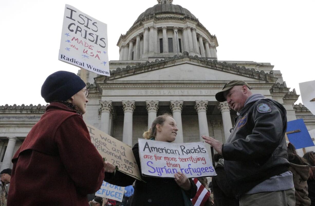 Protesters on opposing sides of the Syrian refugee resettlement issue rally Friday in front of the state Capitol in Olympia. Gov. Jay Inslee has said the state will welcome refugees and has criticized other governors who have threatened to stop accepting them.