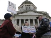 Protesters on opposing sides of the Syrian refugee resettlement issue rally Friday in front of the state Capitol in Olympia. Gov. Jay Inslee has said the state will welcome refugees and has criticized other governors who have threatened to stop accepting them.