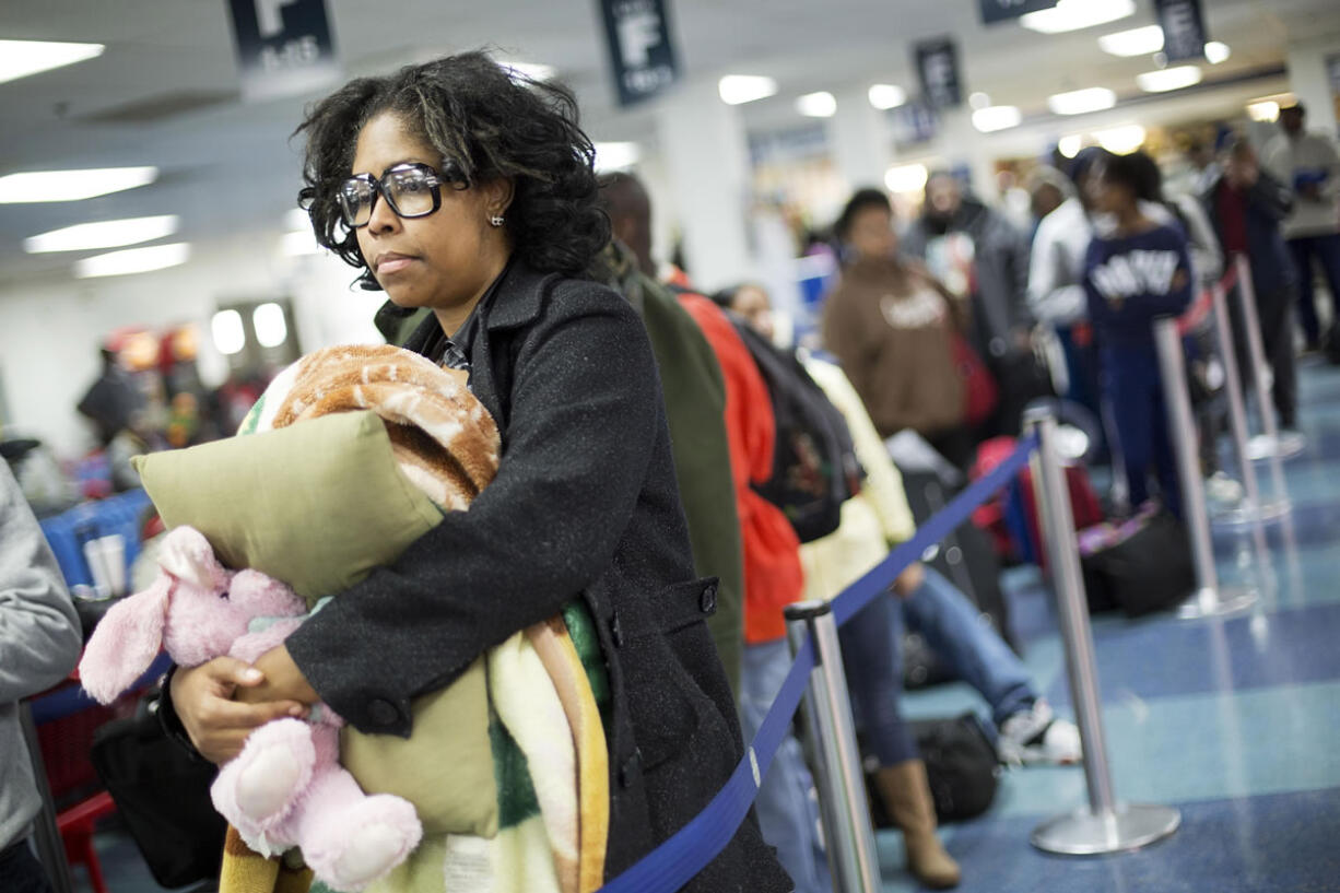 Valarie Settle, of Roanoke Va., waits in line at a Greyhound station to board a bus as she heads to California for the Thanksgiving holiday Tuesday, Nov. 24, 2015, in Atlanta. An estimated 46.9 million Americans are expected to take a car, plane, bus or train at least 50 miles from home over the long holiday weekend, according to the motoring organization AAA. That would be an increase of more than 300,000 people over last year, and the most travelers since 2007.