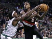 Boston Celtics forward Gerald Wallace, left, tries to knock the ball away from Portland Trail Blazers power forward Thomas Robinson (41) on a drive to the basket during the second half of an NBA basketball game in Boston, Friday, Nov. 15, 2013. The Trail Blazers won 109-96.