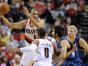 Minnesota Timberwolves' Ricky Rubio (9) defends as Portland Trail Blazers' Nicolas Batum (88) looks to pass during the first half of an NBA basketball game in Portland, Ore., Sunday Feb. 23, 2014.