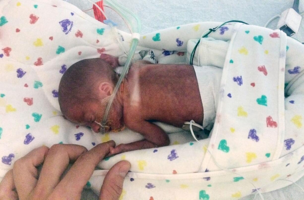 Chase Morgan holds his son Haiden&#039;s hand Sept. 11 at the Miami Children&#039;s Hospital. Haiden, who has spent the past two months in the Miami hospital after his premature birth on a cruise ship, and his mother, Emily Morgan, arrived home in Ogden, Utah, on Saturday.