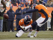 Denver Broncos kicker Matt Prater, right, kicks a 64-yard field goal as Britton Colquitt holds during the first half of an NFL football game against the Tennessee Titans on Sunday, Dec. 8, 2013, in Denver.