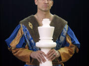 Michael Fisher, of Pittsford, N.Y., holds an oversized chess piece.