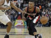 Portland Trail Blazers' Damian Lillard (0) moves to ball past San Antonio Spurs' Boris Diaw (33) during the first half of an NBA basketball game, Monday, Nov. 16, 2015, in San Antonio.