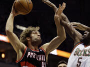 Portland Trail blazers' Robin Lopez (42) goes up for a shot against the Milwaukee Bucks' Ekpe Udoh, right, during the first half of an NBA basketball game on Wednesday, Nov. 20, 2013, in Milwaukee.