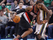 Portland Trail Blazers' LaMarcus Aldridge (12) drives on Utah Jazz's Jeremy Evans, right, in the first quarter  Monday at Salt Lake City.