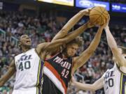 Portland Trail Blazers' Robin Lopez (42) battles with Utah Jazz's Jeremy Evans (40) and  Gordon Hayward (20) for a rebound Dec.