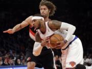 New York Knicks' Carmelo Anthony (7) drives past Portland Trail Blazers' Robin Lopez (42) during the first half of an NBA basketball game, Wednesday, Feb. 5, 2014, in New York.