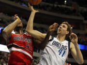 Portland Trail Blazers forward Thomas Robinson, left, and Dallas Mavericks forward Dirk Nowitzki, right, of Germany, fight for a loose ball during the first half of an NBA basketball game on Friday, March 7, 2014, in Dallas. (AP Photo/John F.