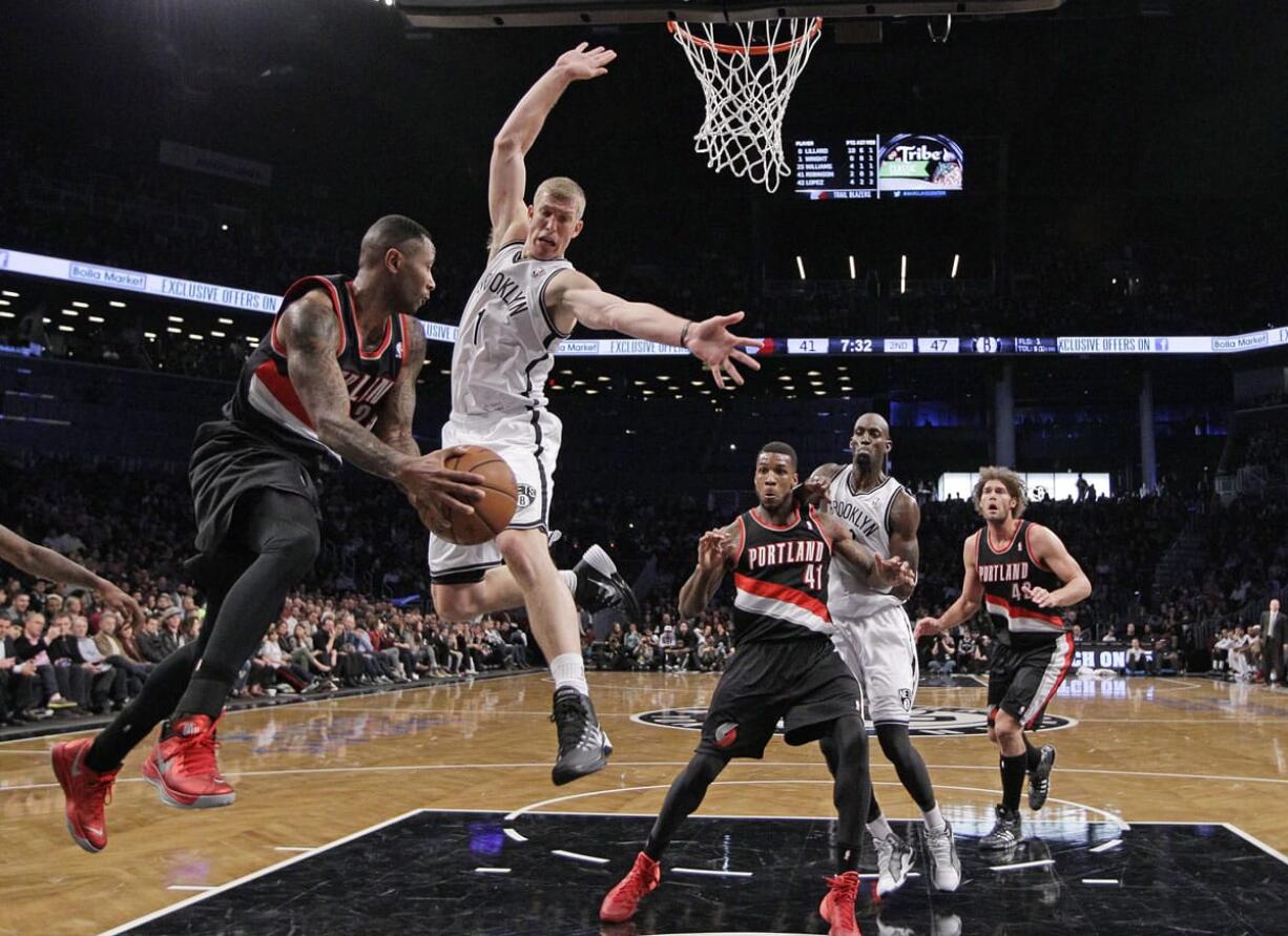 Portland's Mo Williams looks to pass around Brooklyn Nets' Mason Plumlee (1) to teammate Thomas Robinson (41) in the first half Monday at Brooklyn.