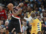 Portland Trail Blazers center LaMarcus Aldridge, left, works the ball inside for a shot as Denver Nuggets forward J.J.