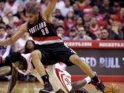 Portland's Nicolas Batum falls on Houston's Patrick Beverley while chasing a loose ball during the fourth quarter Sunday.