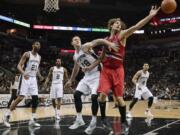 Portland Trail Blazers center Robin Lopez, right, and San Antonio Spurs forward Aron Baynes (16) watch a loose ball during the second half Wednesday in San Antonio.