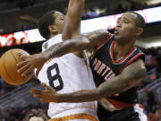 Portland Trail Blazers' Mo Williams passes the ball around Phoenix Suns' Channing Frye (8) during the first half in an NBA basketball game Wednesday, Oct.