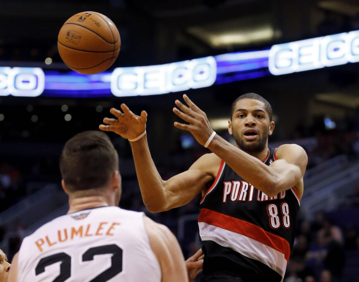 Portland Trail Blazers' Nicolas Batum (88) passes as Phoenix Suns' Miles Blumlee (22) looks on during the first half Wednesday.