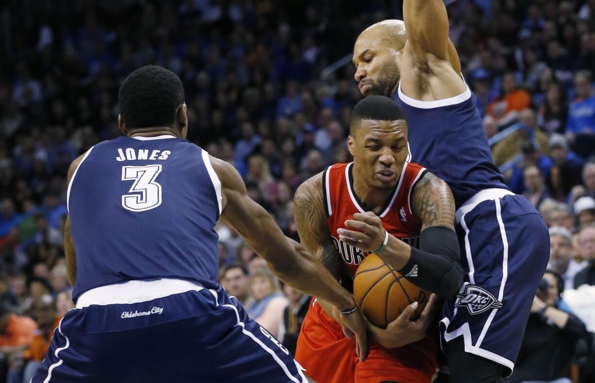 Portland Trail Blazers guard Damian Lillard drives between Oklahoma City Thunder forward Perry Jones (3) and guard Derek Fisher (6) during a recent game.