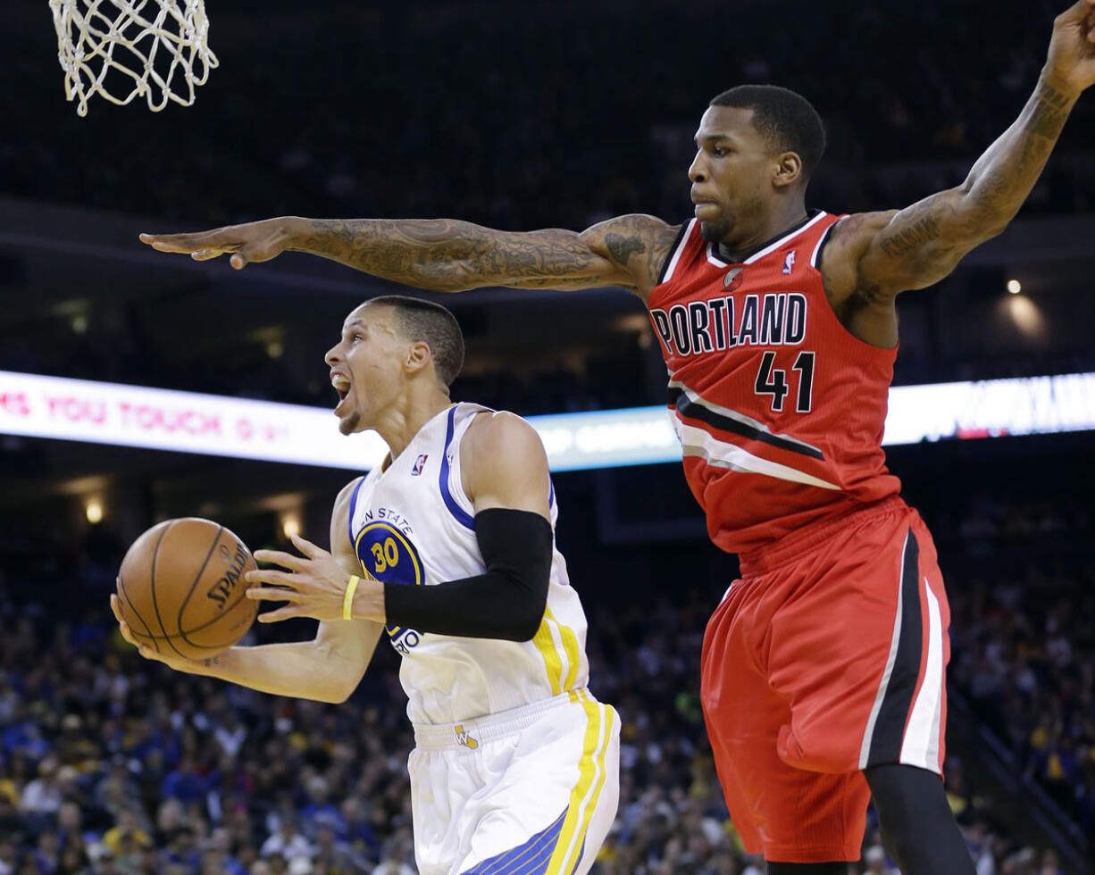 Golden State Warriors' Stephen Curry (30) drives past Portland Trail Blazers' Thomas Robinson (41) during the second half of an NBA basketball game on Sunday, Jan. 26, 2014, in Oakland, Calif. Golden State won 103-88.